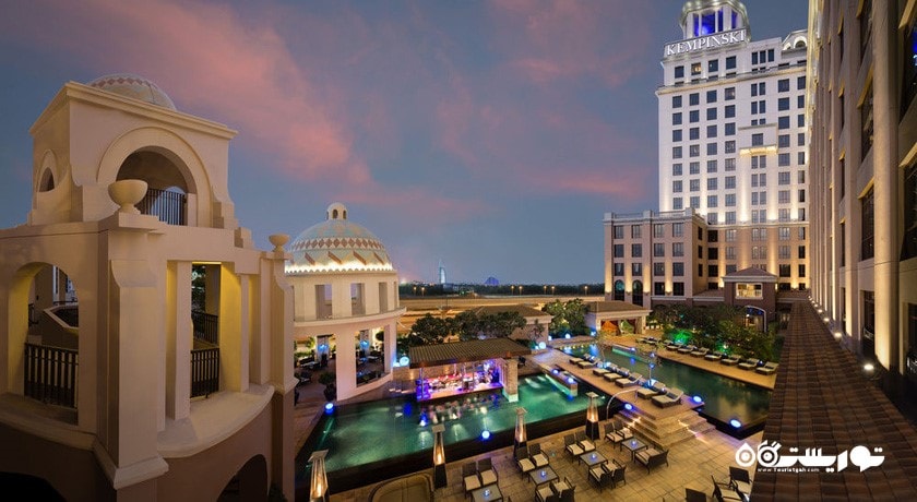 نمای کلی از استخر روباز و ساختمان هتل