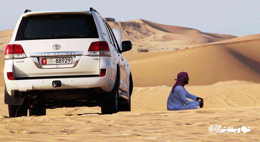سرگرمی سواری با خودروی شاستی بلند در تپه های شنی شهر امارات متحده عربی کشور ابوظبی