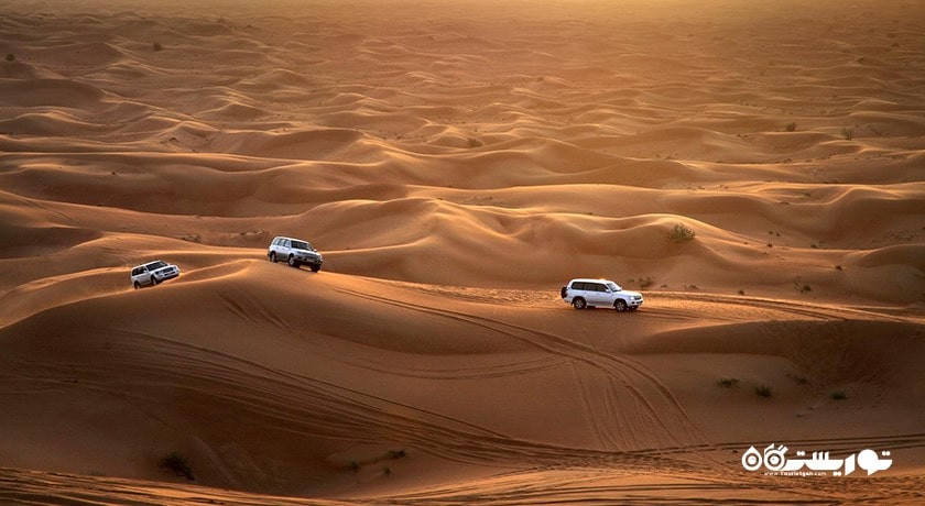 سرگرمی سواری با خودروی شاستی بلند در تپه های شنی شهر امارات متحده عربی کشور ابوظبی