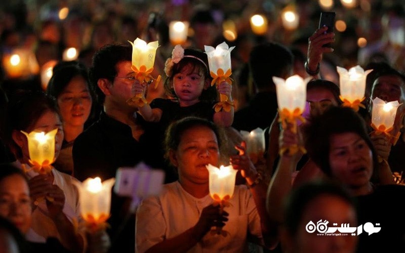 مردم تایلندی با در دست داشتن شمع به منظور دعا
